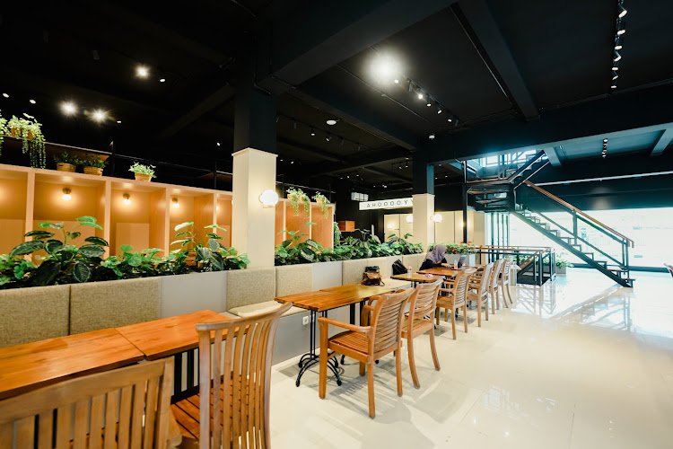 Suasana KLA Co-Working Space Jogja, area duduk dengan meja kayu dan tanaman hijau